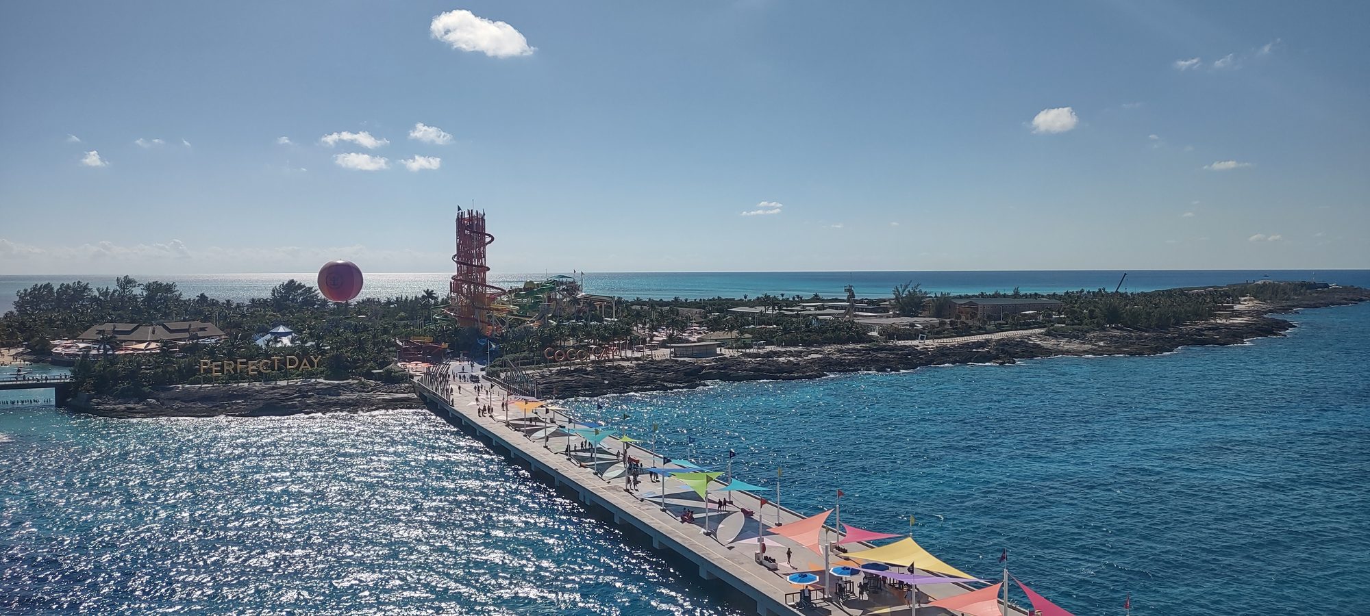 Perfect Day at CocoCay seen from a ship, with the pier, the Perfect Day sign and the waterpark tower